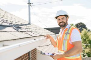 Professional roofer inspecting a home’s roof and gutters during a roof inspection. | two rivers roofing, inc Professional roofer inspecting a home’s roof and gutters during a roof inspection.